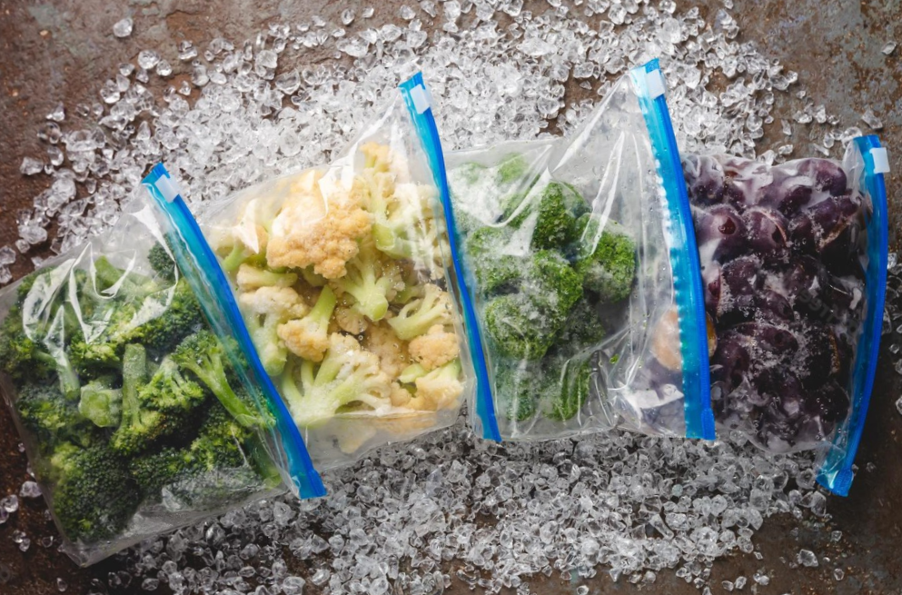 high-angle shot of frozen veggies stored in bags over crushed ice
