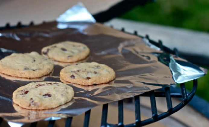 chocolate chip cookies on tin foil on a rack