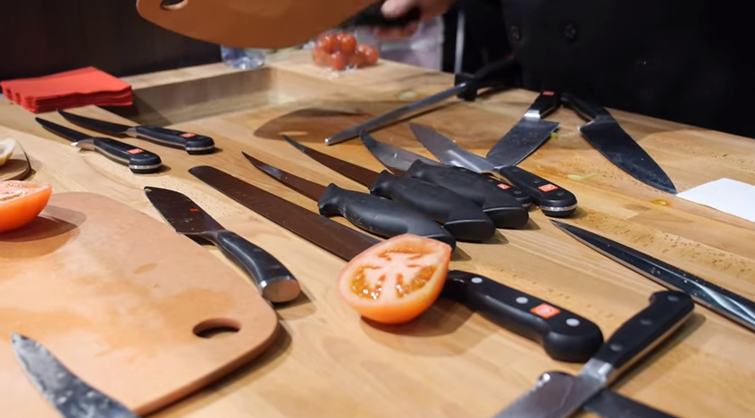 many types of kitchen knives on a table